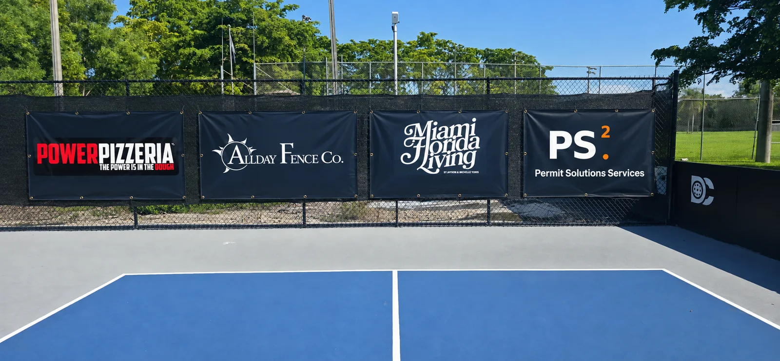 Four 4 by 6 foot fence banners in a row on the chain link behind a Dink Club court: Power Pizzeria, Allday Fence, Miami Florida Living and Permit Solutions Services